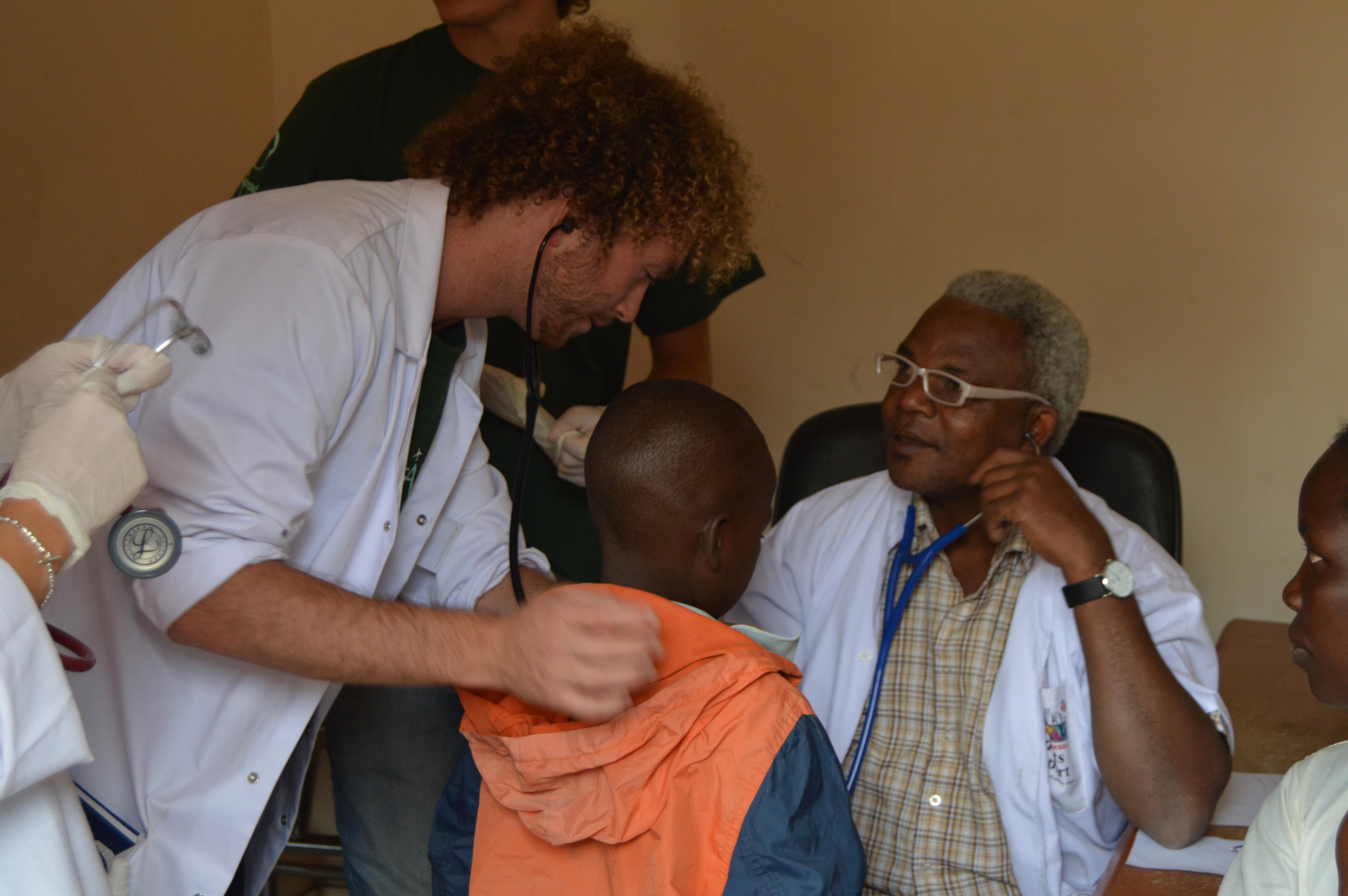 High school students observe a general consultation on their medical internship in Tanzania with Projects Abroad A doctor demonstrates measuring heart rate on our medical internship for teenagers in Tanzania